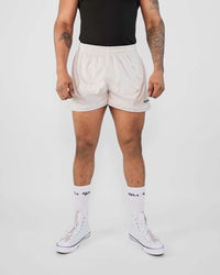 Beige 3-inch inseam mesh shorts with adjustable cords and zippers, highlighting muscular quads. Perfect for movement and comfort.