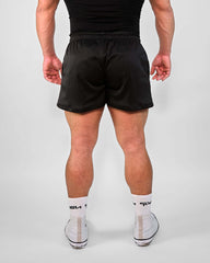 Rear view of a model wearing 3-inch mesh shorts, showcasing the breathable design and slim fit.