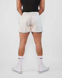 Rear view of a model wearing 3-inch mesh shorts, showcasing the breathable design and slim fit.