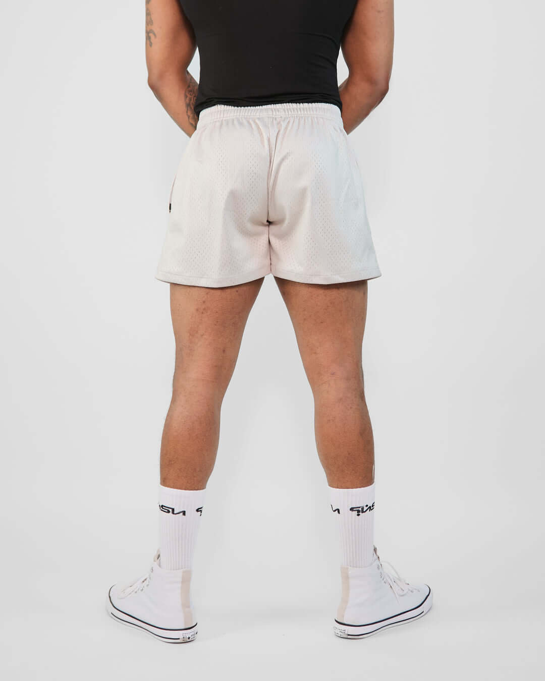 Rear view of a model wearing 3-inch mesh shorts, showcasing the breathable design and slim fit.