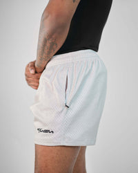 Male model showcasing 3-inch inseam mesh shorts with zippered pockets and breathable polyester fabric.