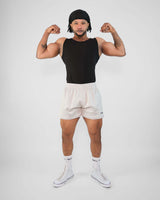 Muscular man flexing in black tank top and 3-inch mesh shorts, showcasing athletic wear and fitness style.
